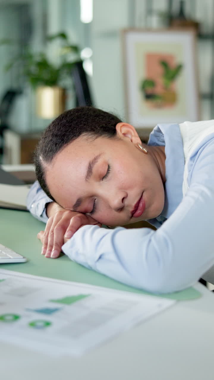 Donna stanca che dorme alla scrivania in ufficio