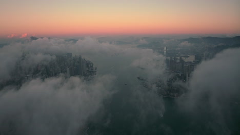 beautifull colored horizon before sunrise with white clouds slowly moving over victoria harbour in hong kong. drone panning shot