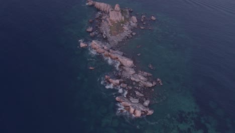 Reveal-shot-of-St-Nedjelja-Church-on-the-rock-in-Petrovac-during-sunset,-aerial