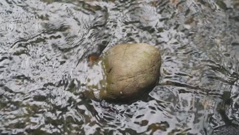 Agua-Clara-Que-Fluye-A-Través-De-Una-Pequeña-Roca-En-Un-Arroyo-En-Kyoto,-Japón---Toma-De-Primer-Plano