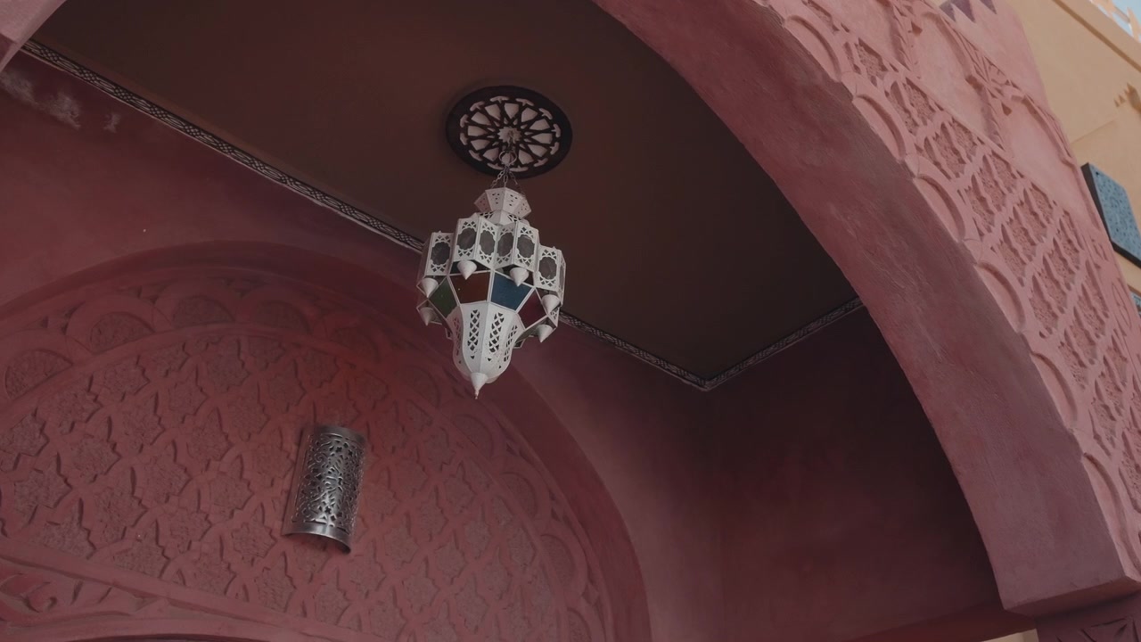 Lanterna tradizionale marocchina appesa a un soffitto in gesso intagliato in un Riad in Marocco.