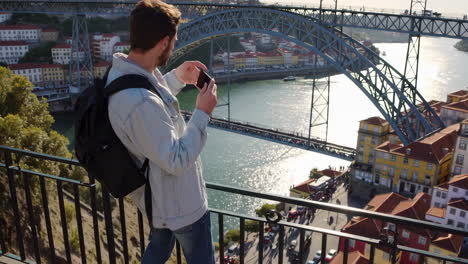 man taking photo of dom luís i bridge in porto