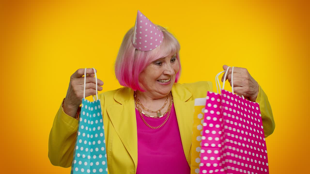 anciana abuela mostrando bolsas de compras, descuentos publicitarios, mirando asombrado con los precios bajos