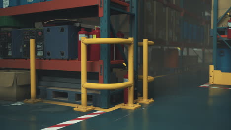 a warehouse interior with pallets, shelves, and safety equipment