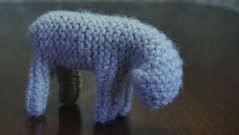 handmade small yarn crochet lamb standing on a wooden table