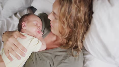 Video-De-Una-Feliz-Madre-Caucásica-Acostada-En-La-Cama-Con-Un-Bebé-Recién-Nacido-Durmiendo