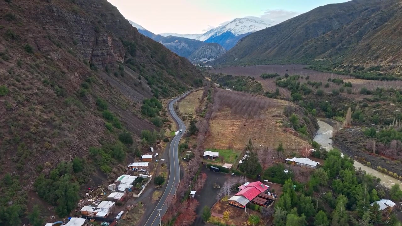 Vista aerea panoramica con inclinazione verso l'alto del percorso attraverso il Cajón del Maipo, Los Andes, Cile.