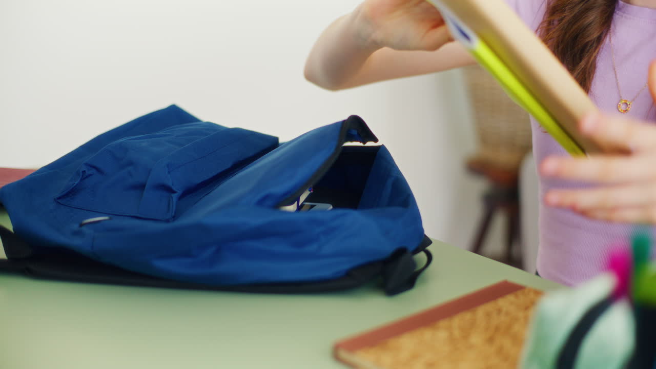 Close-Up of a Girl's Hands Taking Books Out of Her School Backpack