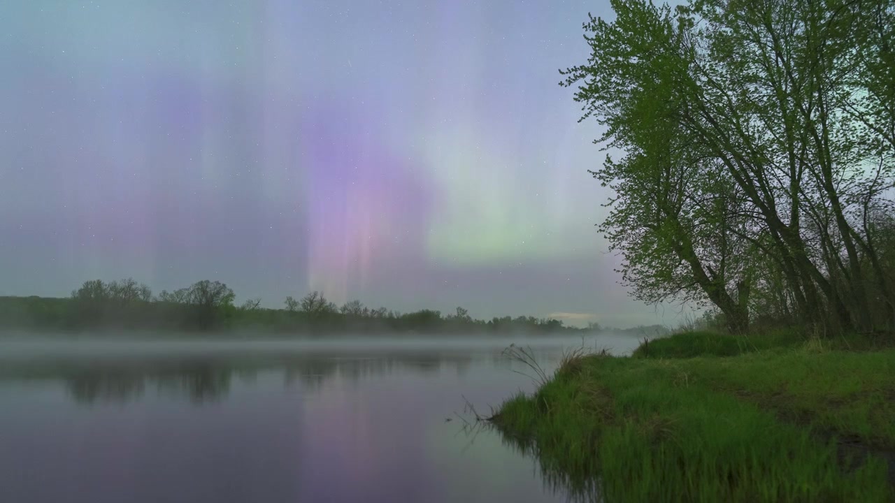 Cortine di aurora viola che ondeggiano e nebbia che si sposta sul fiume St. Croix negli USA. Vista in timelapse
