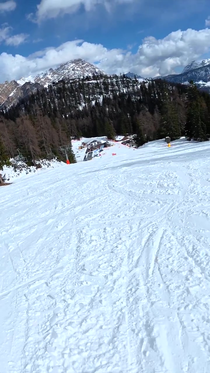 Prospettiva in prima persona di uno sciatore che scende un pendio montano innevato