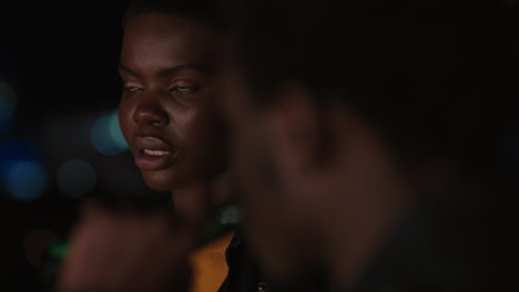 amigos jóvenes pasando el rato en la azotea por la noche charlando teniendo conversación disfrutando de la noche urbana hombre afroamericano coqueteando con una mujer hermosa en una cita