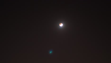 aumento de la luna de sangre y lapso de tiempo de transición con estrellas fugaces en el fondo del cielo rojo oscuro