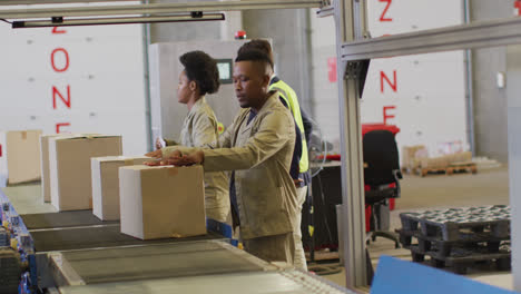 diverse male and female workers with boxes on conveyor belt in warehouse