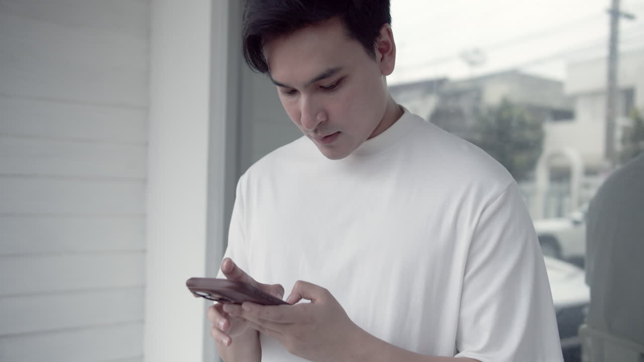 A young man explores his smartphone in a stylish modern environment highlighting digital communication.