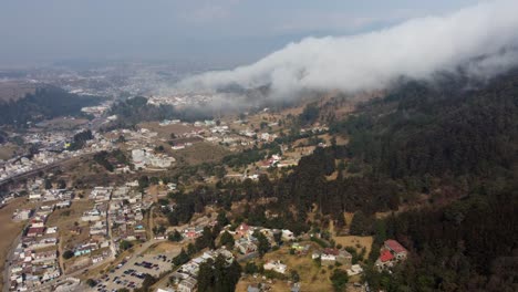 la nube desciende rápidamente por la ladera de la montaña hacia la ciudad en guatemala, aérea