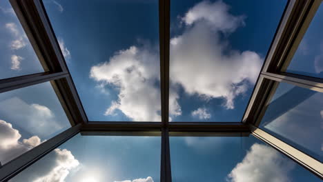 view of blue sky and clouds through an architectural skylight