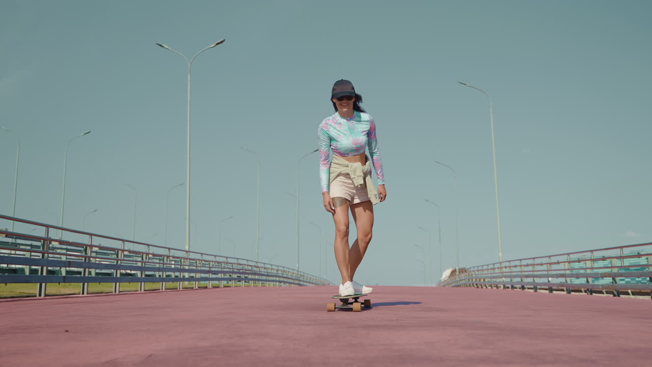 여자 가 다리 에서 스케이트보드를 타고 있다