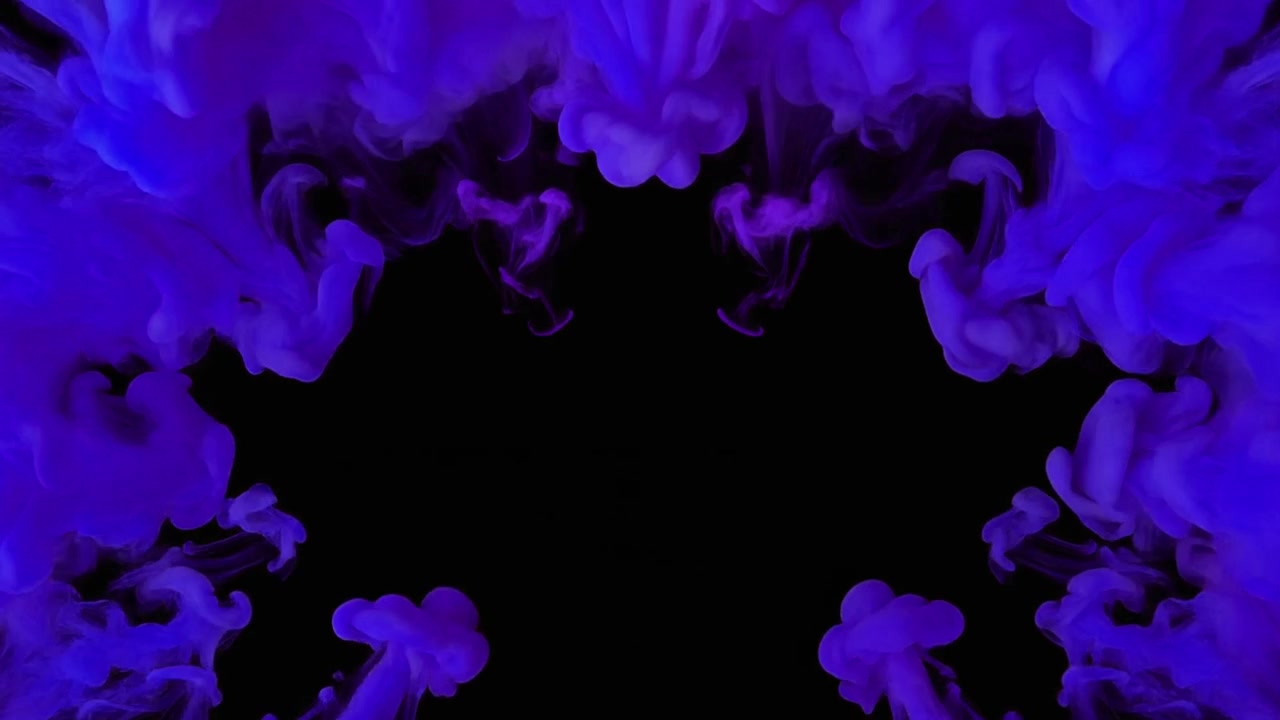 Goccioline di inchiostro viola che si diffondono nell'acqua su sfondo nero