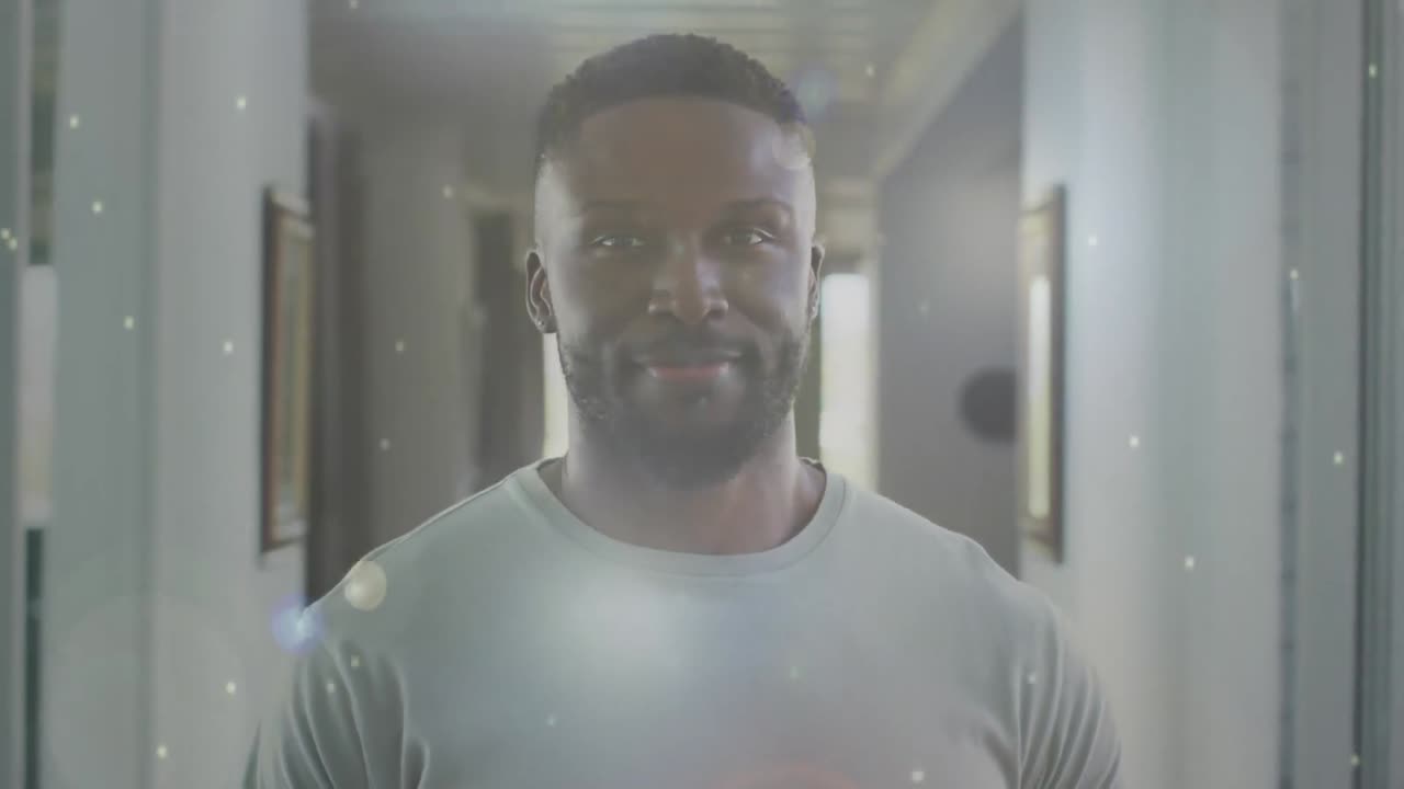 animación de un hombre afroamericano sonriente en casa sobre manchas blancas