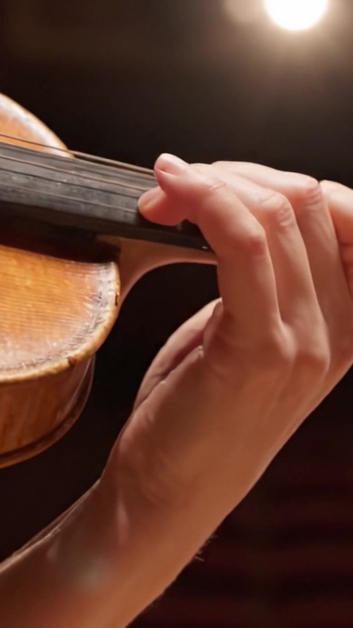 A Close-Up View of Hand Positioning on a Violin Neck, Capturing the Artistry and Technique of String Instrument Performance in a Concert Setting