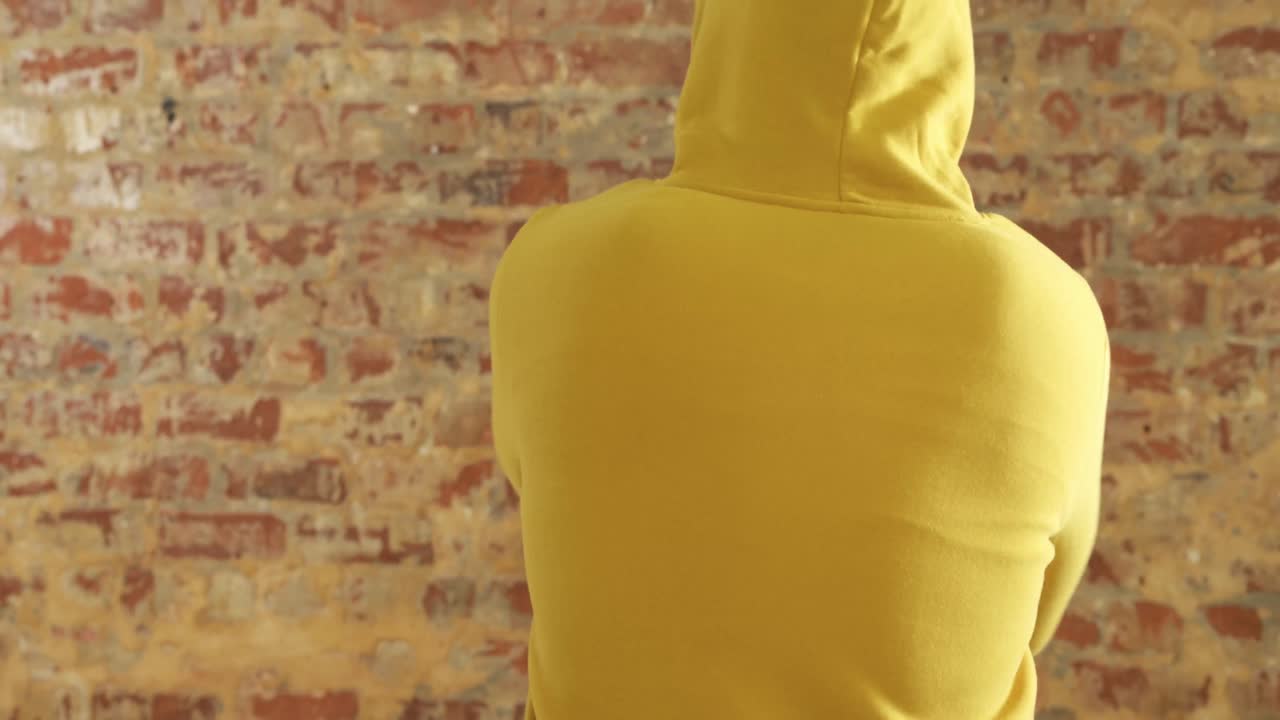 la espalda de un hombre caucásico en una pared de ladrillo