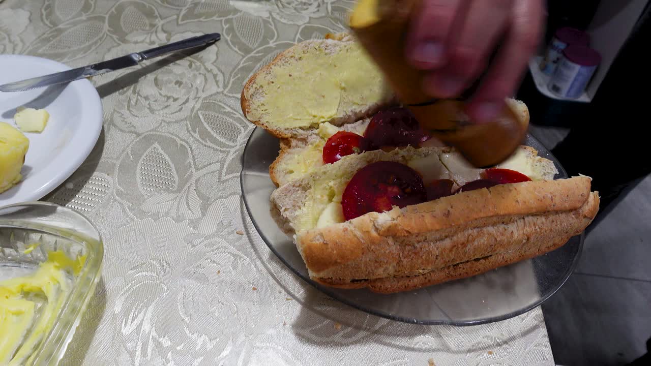 Een sandwich maken: Verse rode tomaten toevoegen aan brood.