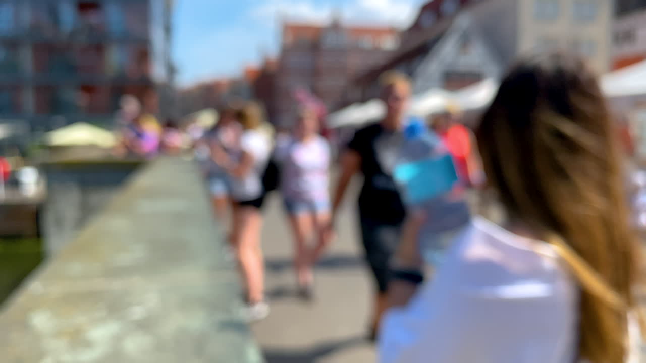 fuera de foco toma de gente caminando en el puente en la ciudad durante el día soleado