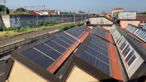 wide view of photovoltaic panels on rooftops in milan, filmed from a taller building. urban solar energy and italian sustainability in action