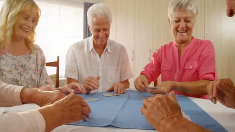 Happy-senior-friends-playing-cards