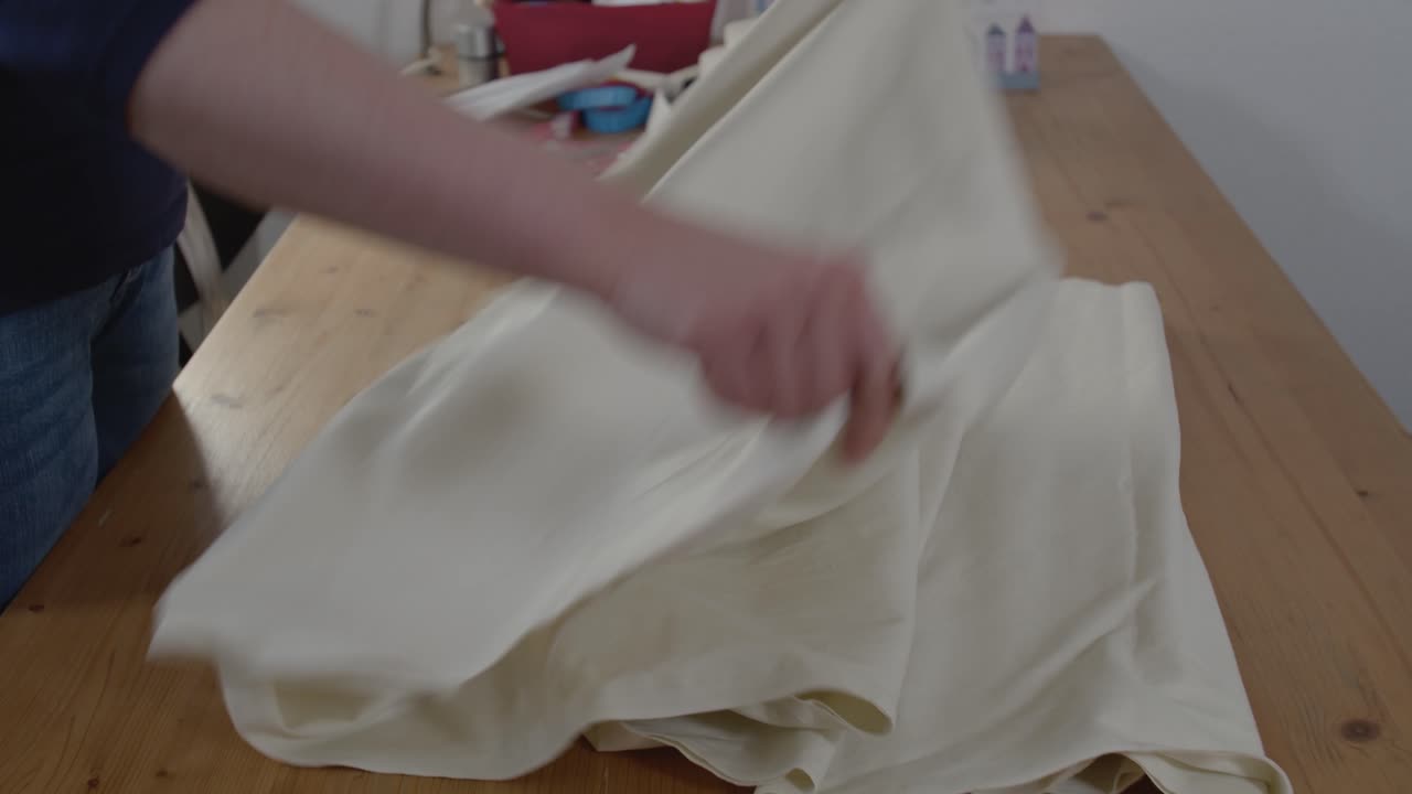 仕立て屋が生地を並べて縫う準備をしているのが見られる