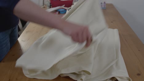 eine näherin legt den stoff aus, der zum nähen vorbereitet werden soll