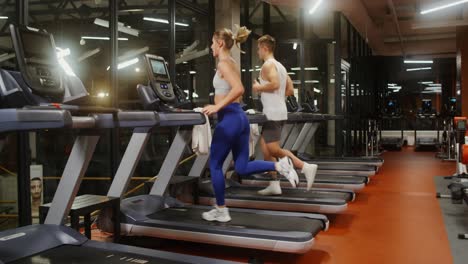 personas corriendo en cintas de correr en un gimnasio