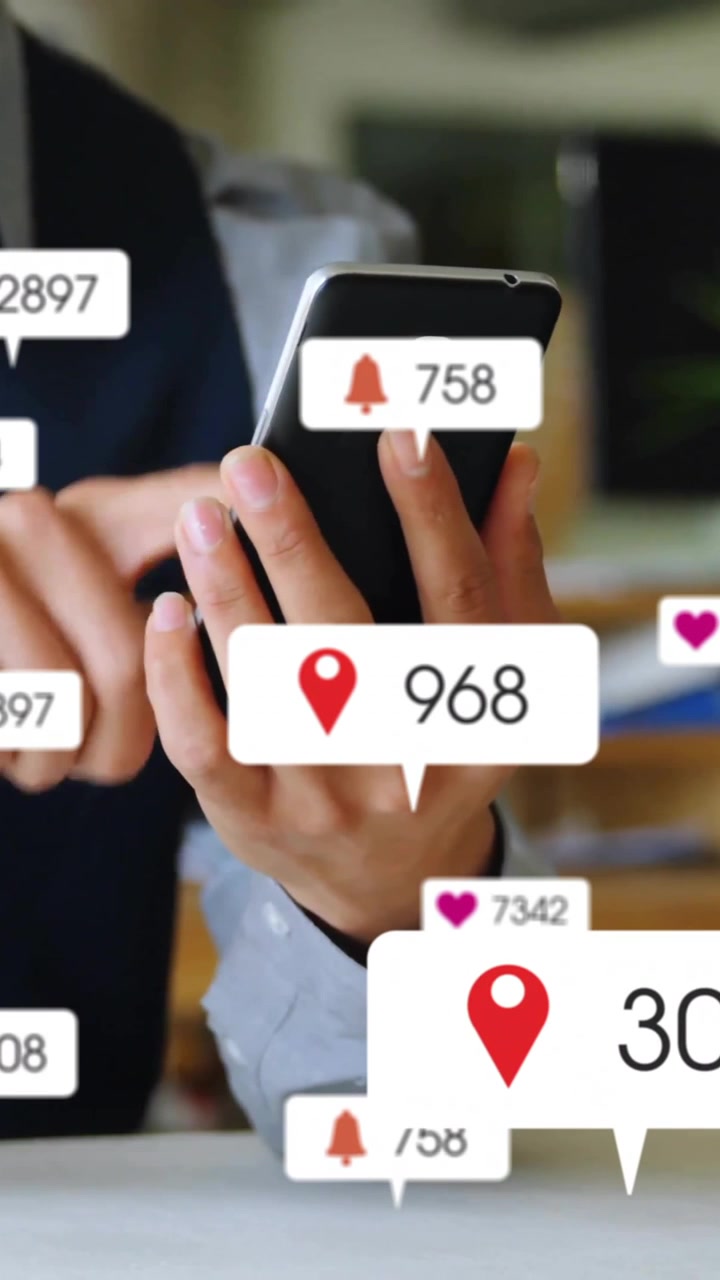 Animation of social media icons with numbers over caucasian businessman using smartphone