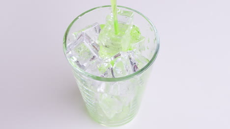 verter refrescos y soda verde en vidrio aislado o fondo blanco.