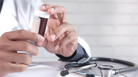 médico con un frasco de pastillas
