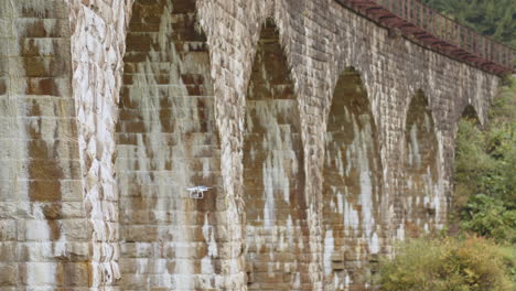 avión no tripulado sobre un puente de piedra histórico