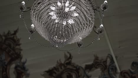 elegante candelabro de cristal con detalles intrincados contra un telón de fondo ornamentado del techo