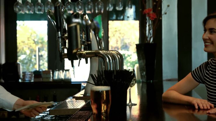 Donna sorridente che parla con il barman