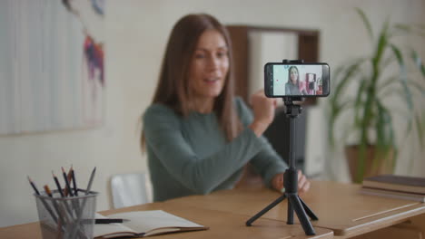 mujer grabando un tutorial de video en casa