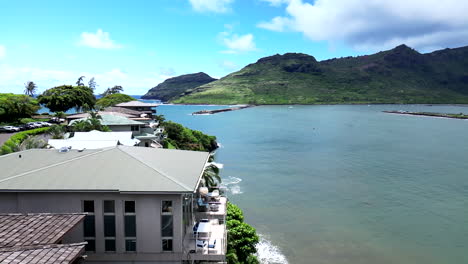 Zoom-Aéreo-Sobre-Mansiones-Junto-A-Acantilados-De-Kauai-Con-Montañas,-Océano-Y-Palmeras