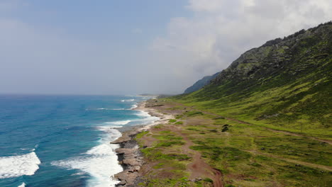 Time-lapse-Aéreo-De-Hermosas-Olas-Del-Océano-Rompiendo-En-La-Costa-De-Hawai-Con-Verdes-Acantilados-De-Montaña-En-El-Fondo