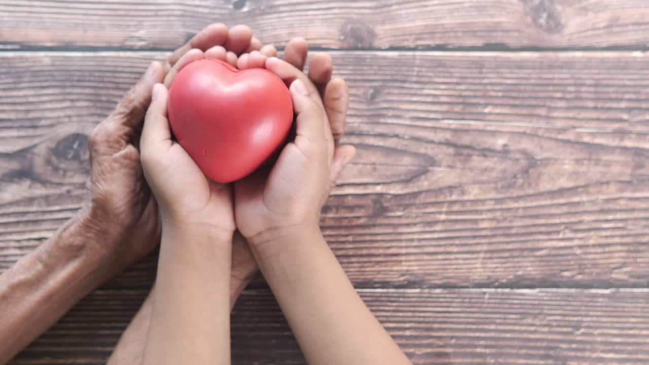 manos sosteniendo un corazón - un símbolo de amor entre generaciones