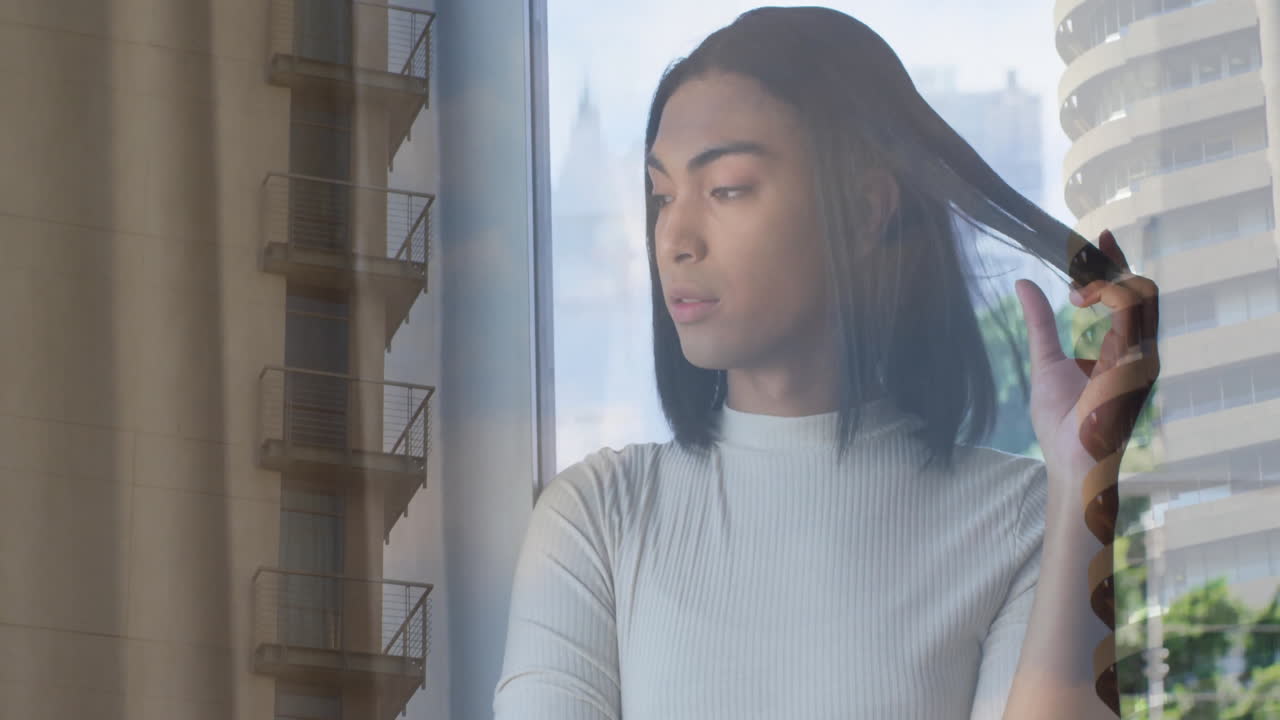 Looking out window, thoughtful person observing city buildings in background