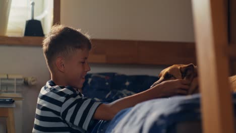 boy playing with dog in bedroom