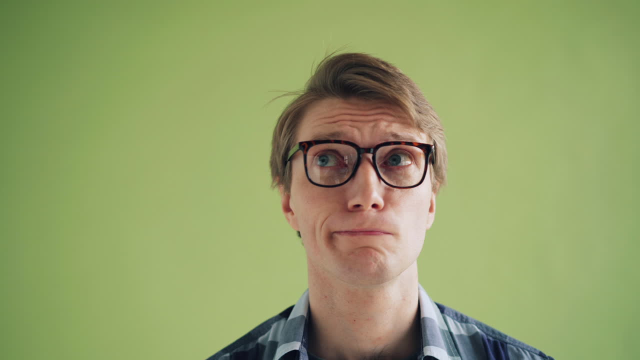 Man wearing glasses in front of a light green background