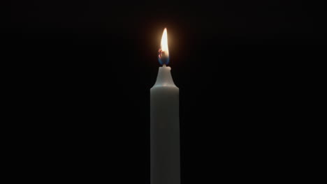 a candle burs out in the dark room