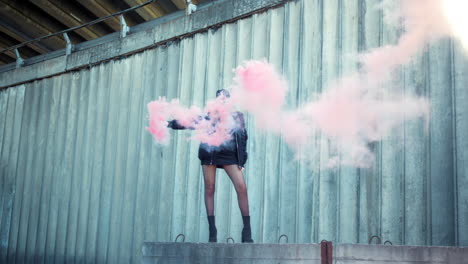 girl standing on street with smoke bomb in hand. woman holding smoke grenade