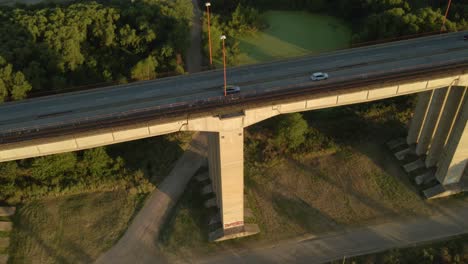 Toma-Aérea-En-ángulo-Alto-Volando-Sobre-El-Tráfico-Conduciendo-En-El-Puente-Zarate-Brazo-Largo-A-La-Hora-Dorada