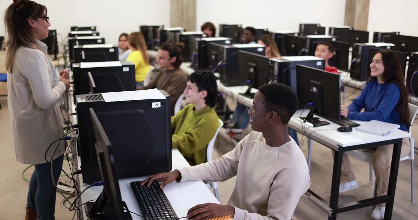 Insegnante che guida una lezione di informatica con studenti eterogenei