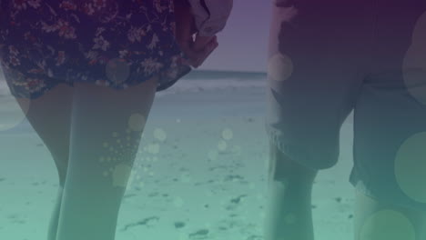 animation of light spots over caucasian couple walking and holding hands